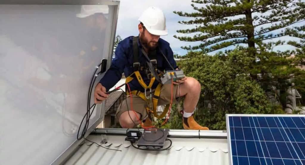 maintenance man testing solar panel using multimeter