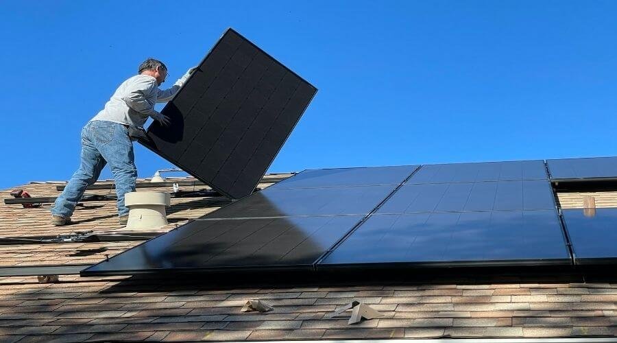 man installing solar attic fan