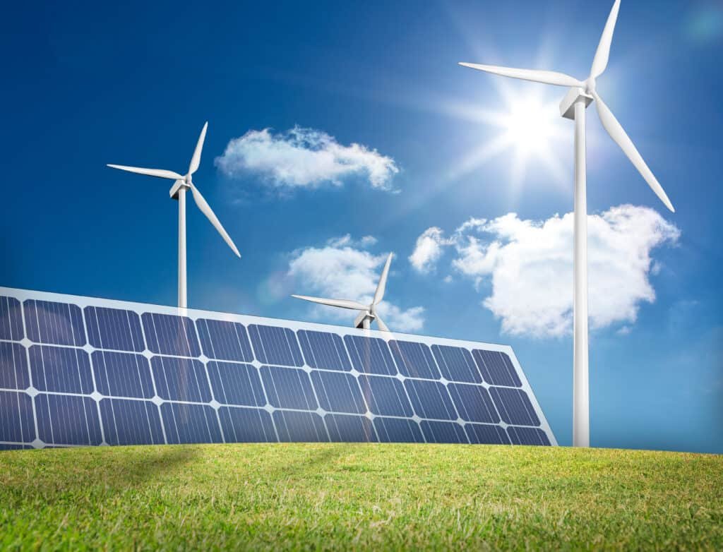 Large solar panel and three wind turbines in a sunny field