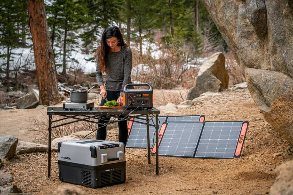women cooking in the forest with a portable solar panels