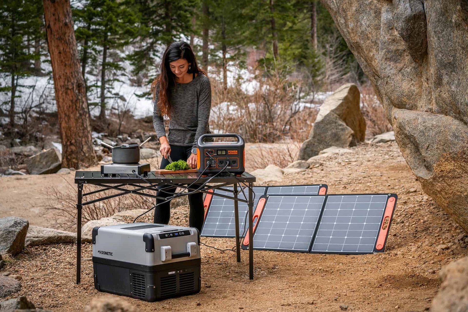 women cooking in the forest with a portable solar panels
