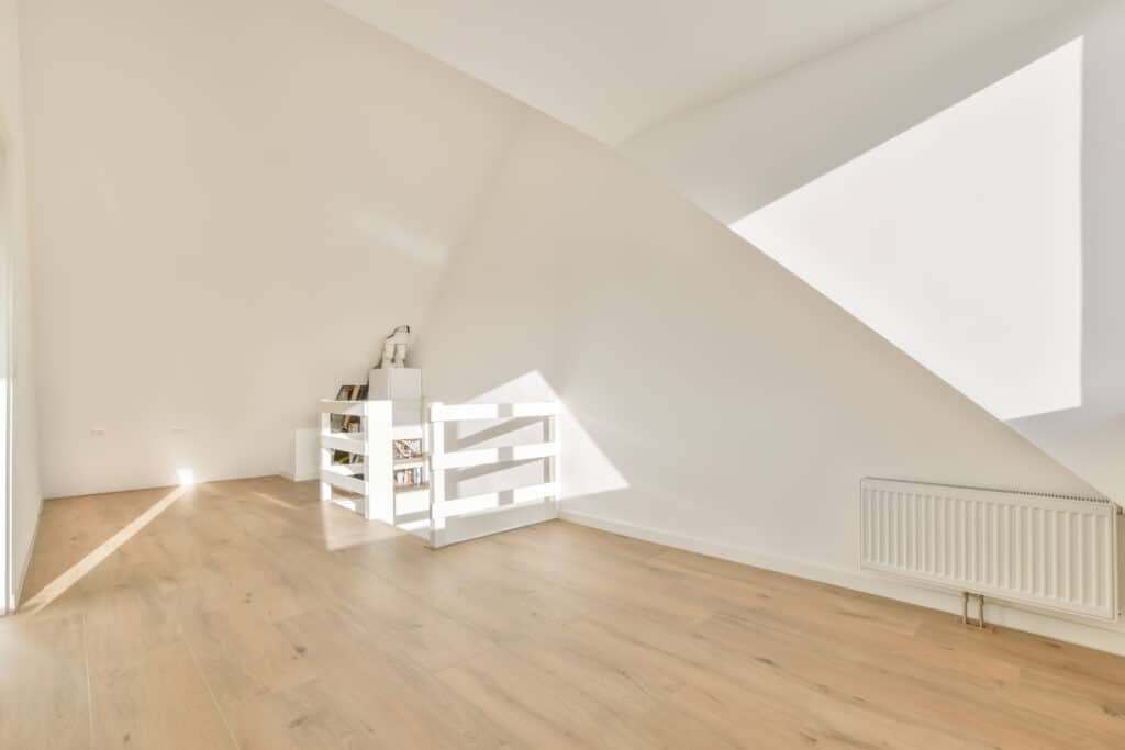Spacious empty attic room with stairs