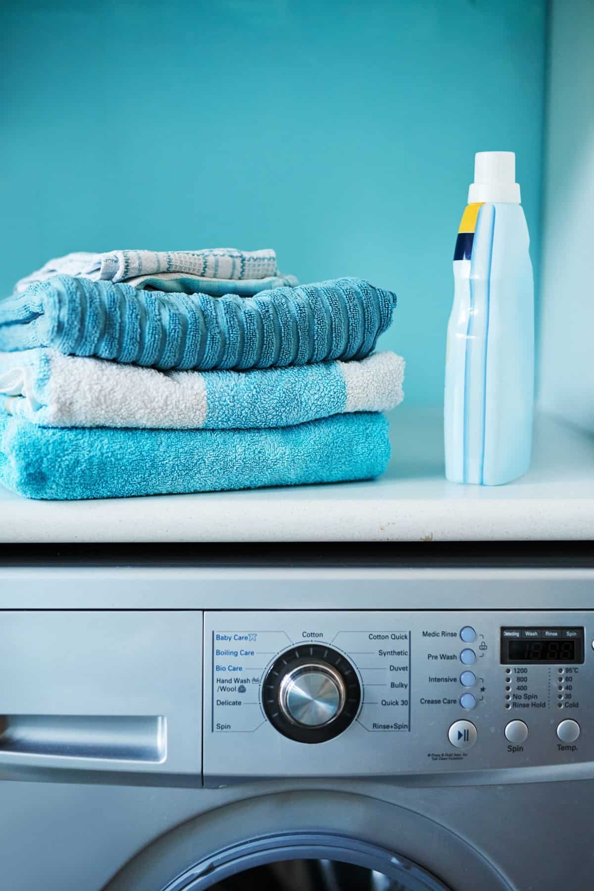 washing machine with clothes and laundry soap at the top