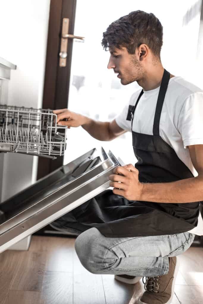 young man using dishwasher in his kitchen