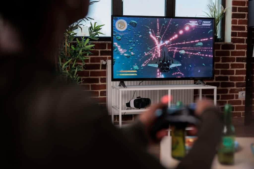 African american woman playing video games with television console