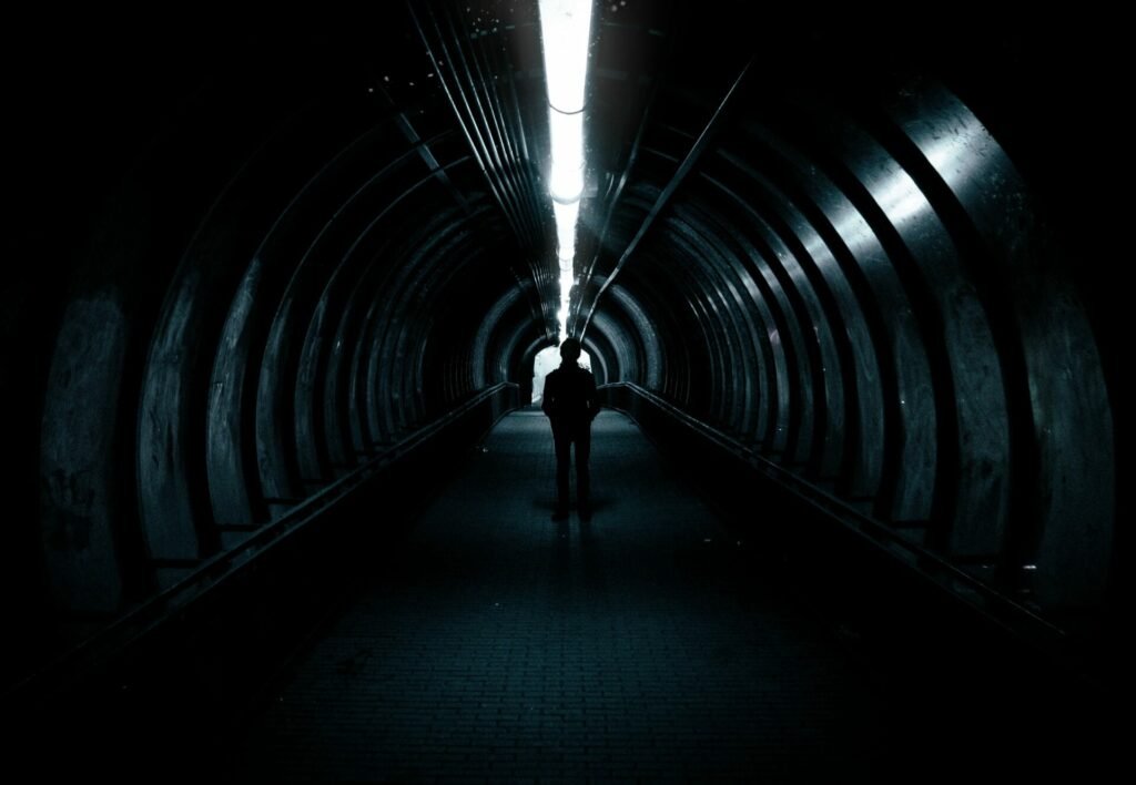 man walking on a tunnel with a solar tube lights